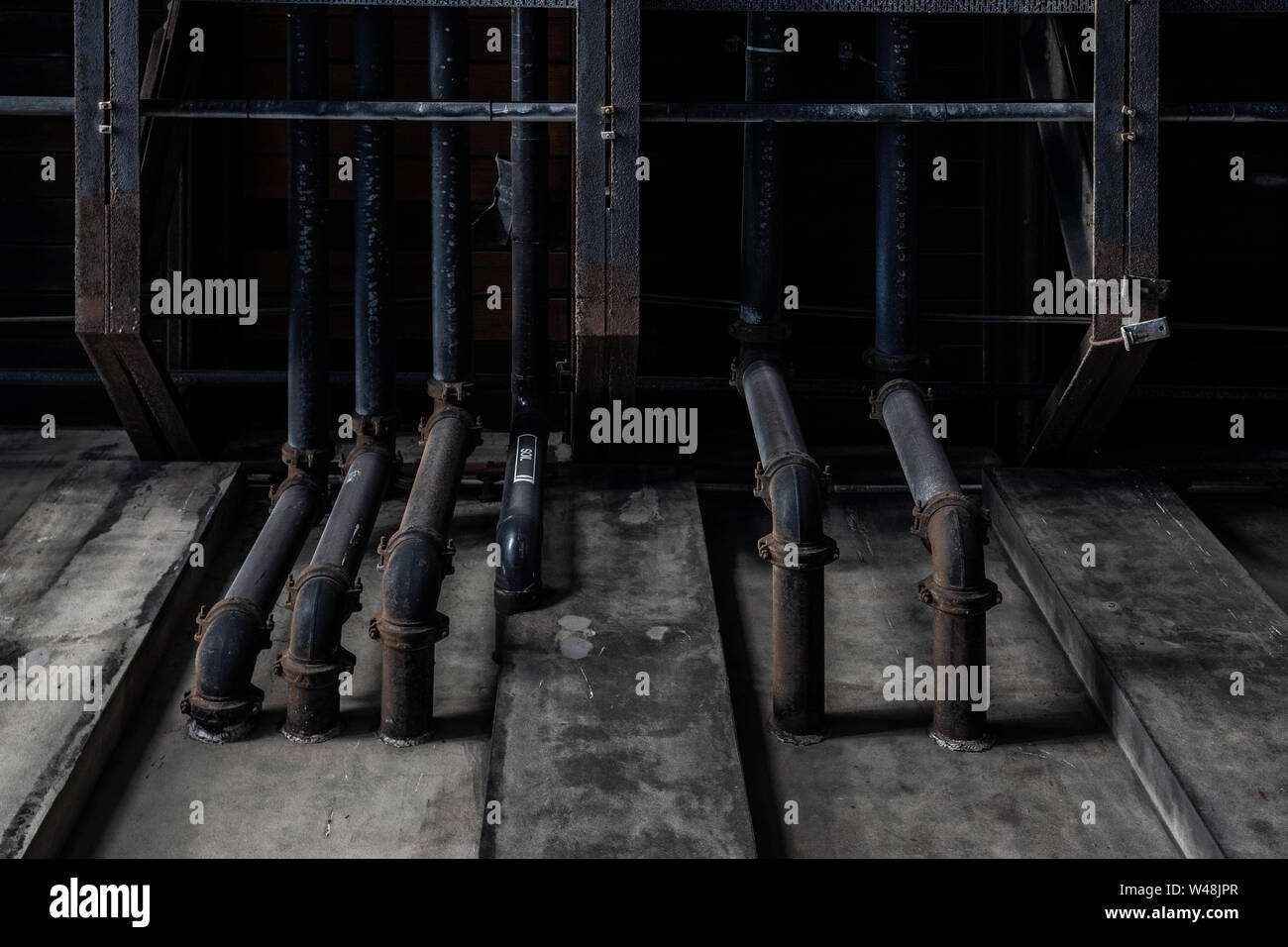 Schmutzige schwarze Rohre aus Beton Wand. Textur Hintergrund Grafik Asset. Stockfoto