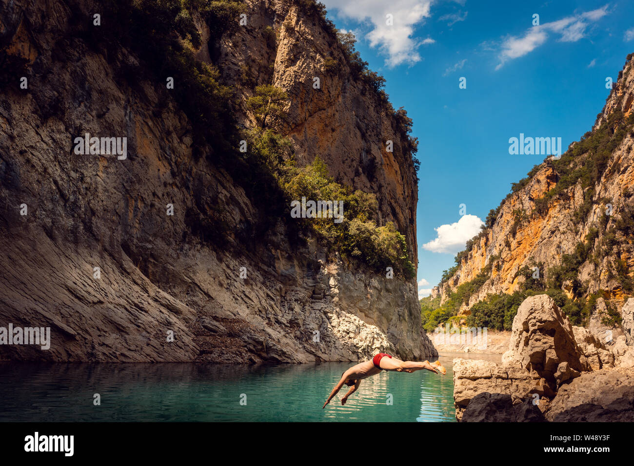 Mann in das Wasser von einer Schlucht in den Bergen der Pyrenäen springen Stockfoto