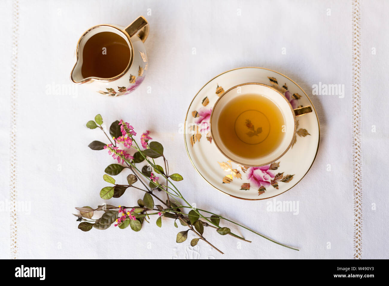 Tea Time mit Blumen auf einem weißen Tischtuch Stockfoto