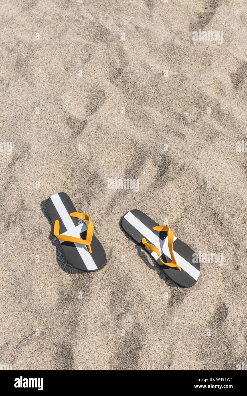 Cornish St. Piran Flagge flip flops & Sandstrand. Metapher UK staycation, Urlaub zu Hause, Cornwall Ferienhäuser, Cornish Urlaub, flip flop Schuhe Stockfoto