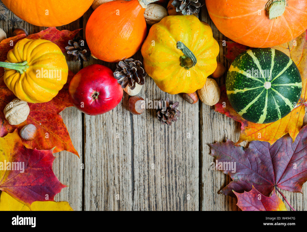 Herbst Natur Konzept. Herbst Obst und Gemüse mit Ahorn Blätter, Nüsse und Tannenzapfen auf hölzernen Tisch. Danksagung Hintergrund Stockfoto