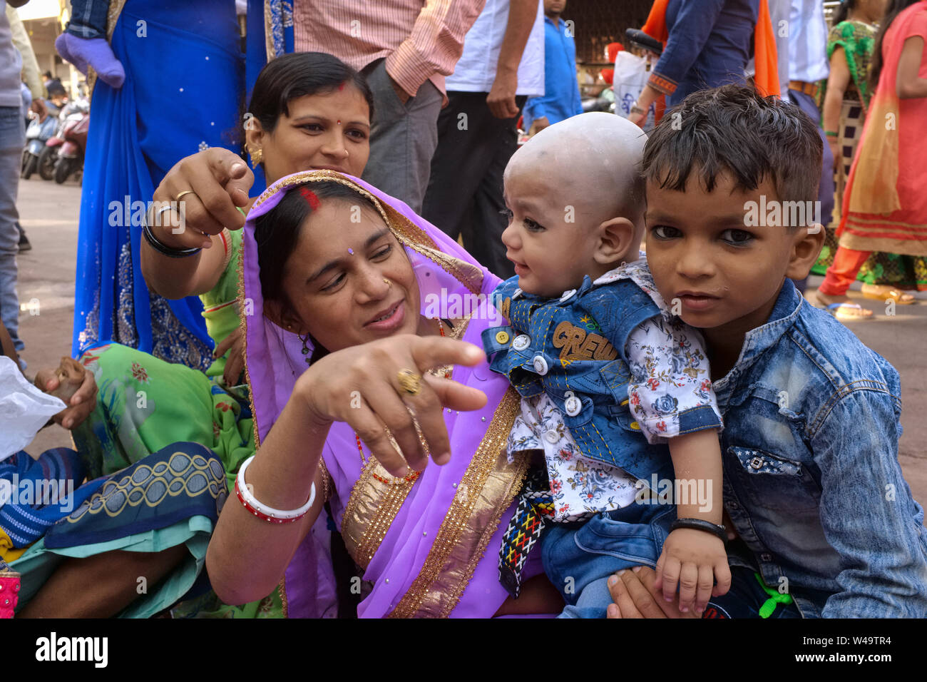 Mitglieder einer indischen Joint family, den Migranten aus dem nördlichen Bundesstaat Uttar Pradesh, mit zwei jungen jungen Jungen, in Mumbai, Indien posing Stockfoto