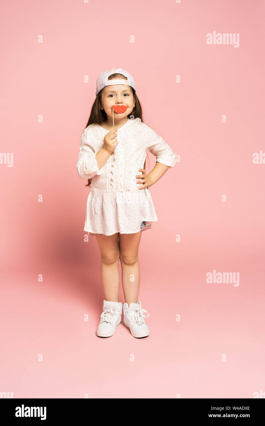 Lachen Mode kleines Mädchen auf rosa Hintergrund isoliert. Stockfoto