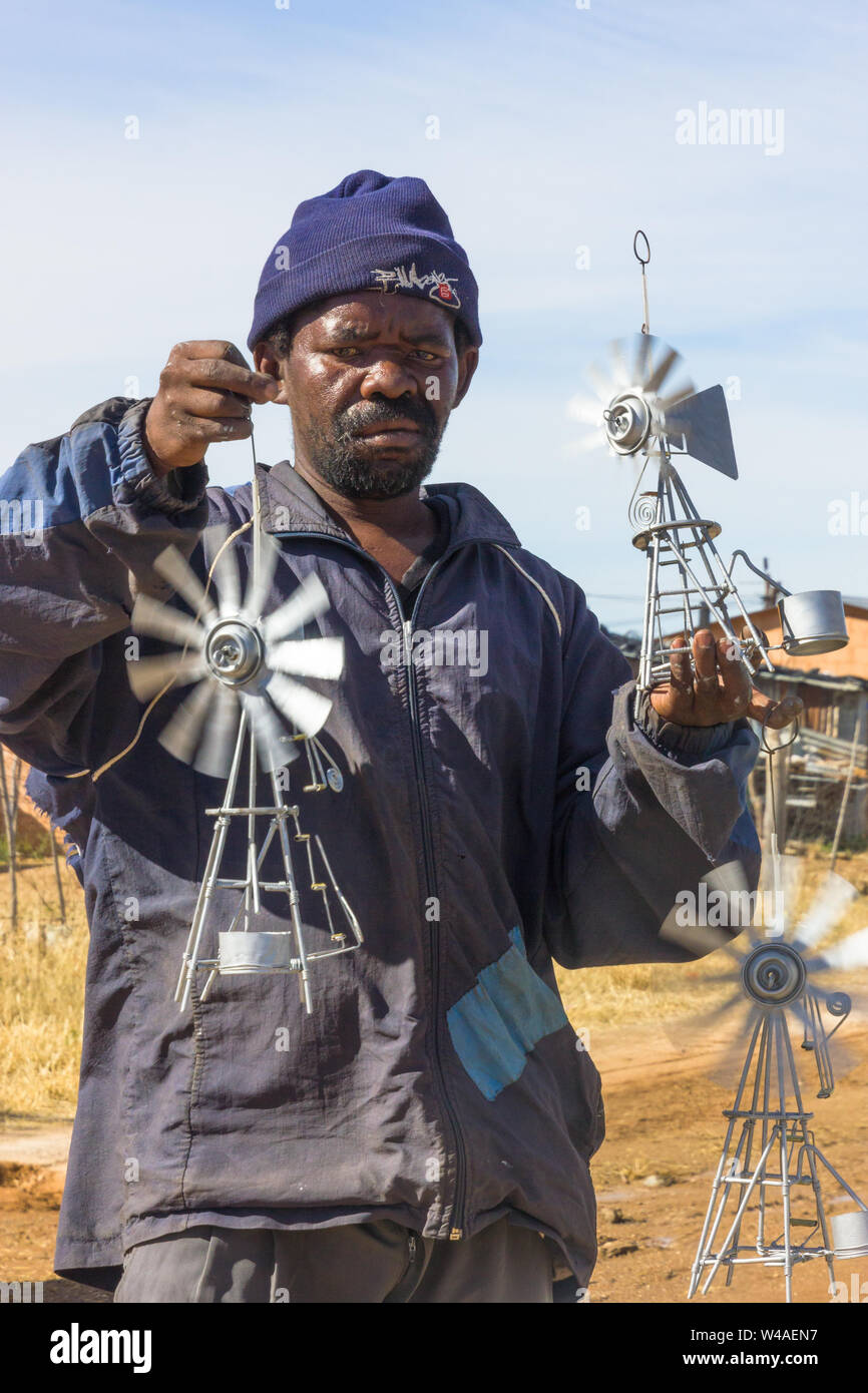 Schwarzer afrikanischer Mann armen Straßenhändler hand Verkauf aus Metall wind Pumpen auf der Seite der Straße im ländlichen Südafrika arbeitet als informelle Händler Stockfoto