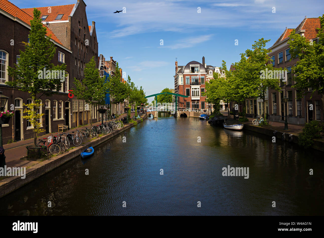 Leiden, Holland, Niederlande, 22. Mai 2019, Fahrräder an einem Kanal geparkt, eine Zugbrücke auf Hintergrund, Boot auf dem Wasser. Stockfoto