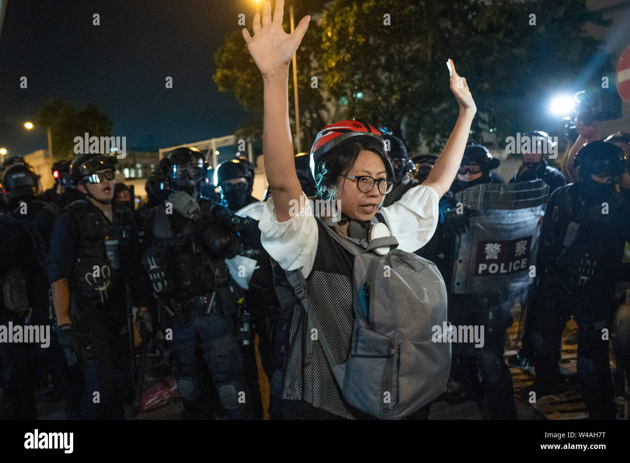 Eine weibliche Demonstrant wirft ihre Arme vor der Polizei in einem Versuch der Polizei gegenüber der Gruppe von Demonstranten zu verlangsamen. die Hong Kong Polizei benutzt hat, Gas- und Bubble Munition gegen Demonstranten zerreißen, während Hunderte von Demonstranten marschierten hat die geplante Demonstration Route. Zehntausende von pro-demokratischen Demonstranten haben wöchentliche Kundgebungen auf den Straßen von Hong Kong gegen die umstrittene Auslieferung Rechnung seit Anfang Juni fortgesetzt. Stockfoto