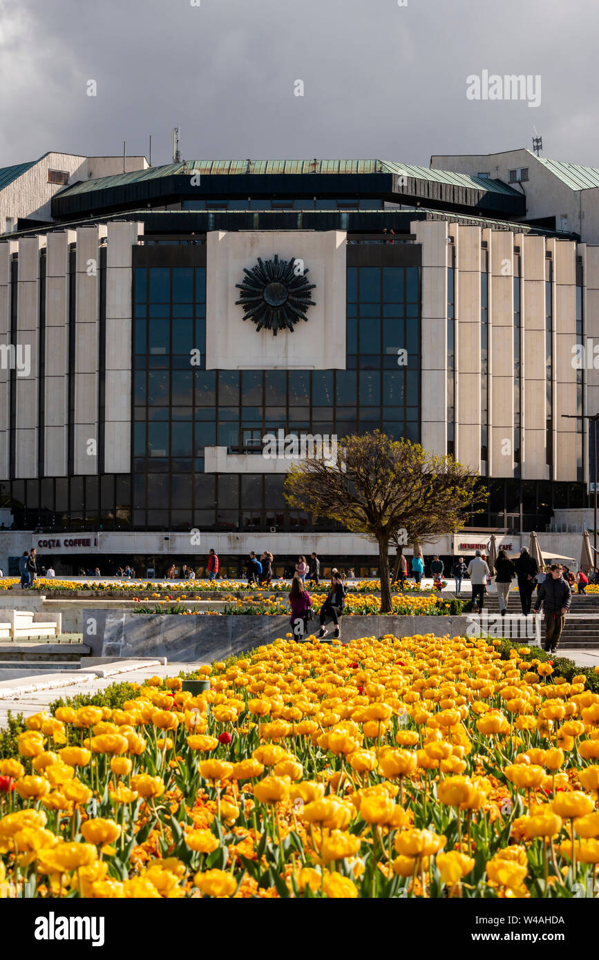 Sofia Bulgarien ikonisches Gebäude des Nationalen Kulturpalastes oder NDK und gelbe Tulpen am sonnigen Frühlingstag, Osteuropa, Balkan, EU Stockfoto