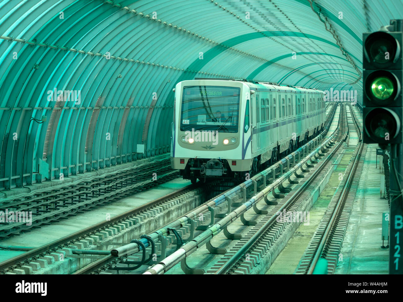 Sofia Metro Train, alte russische U-Bahn, U-Bahn Modell 81-740/741 'Rusich' nähert sich der Station. U-Bahn U-Bahn U-Bahn Linien auf dem Weg zu einer Station, die unter einem grünen, gebogenen Polypropylenrahmen in einem hellen Tunnel vorbeiführt. Stadtverkehrskonzept. Grüne Blockfarbe oder Blockfarbe. Sofia, Bulgarien, EU Stockfoto
