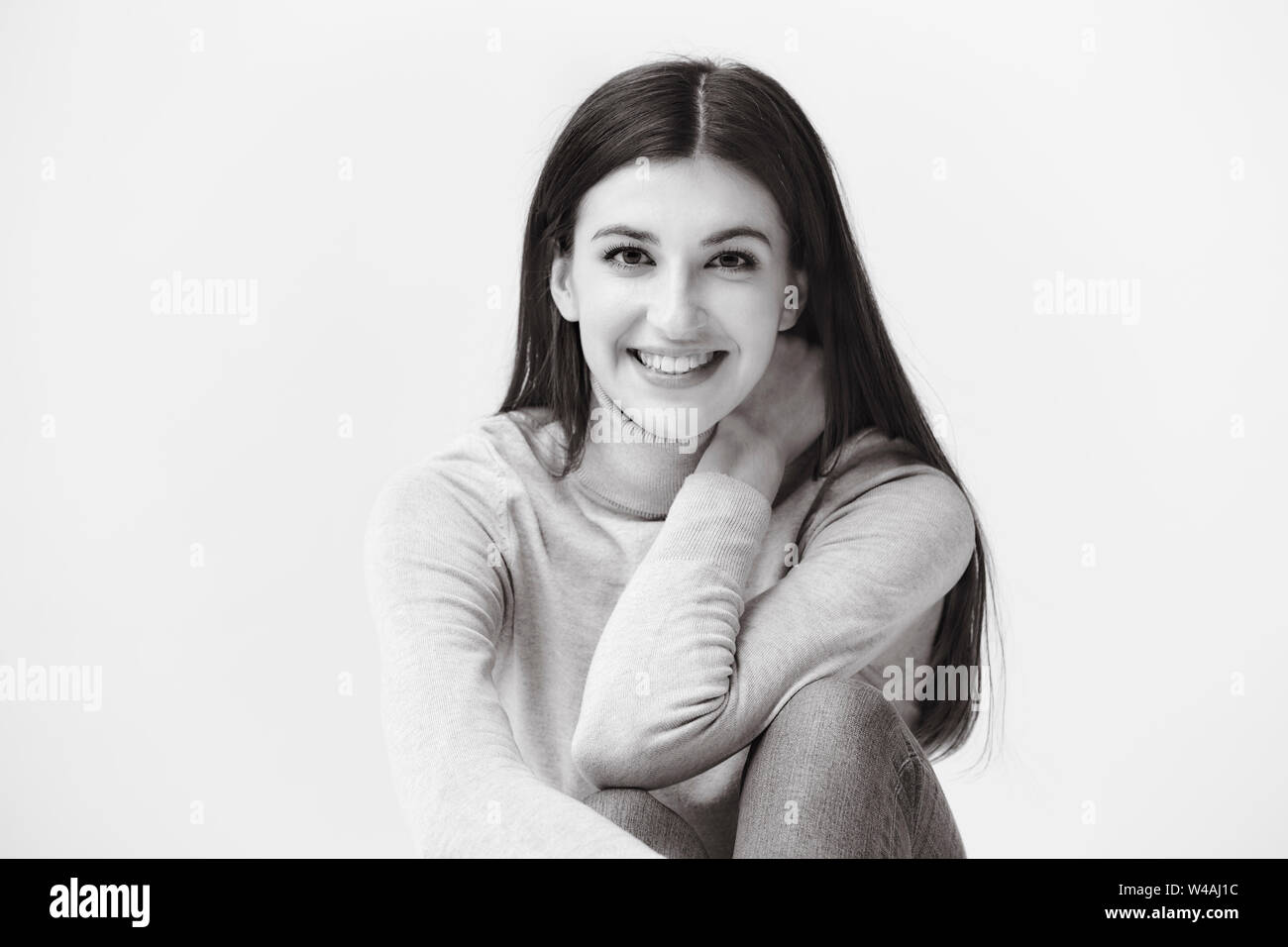 Schwarz-weiß-Porträt einer wunderschönen kaukasische Frau, an der Kamera suchen, glücklich und lächelnd Stockfoto