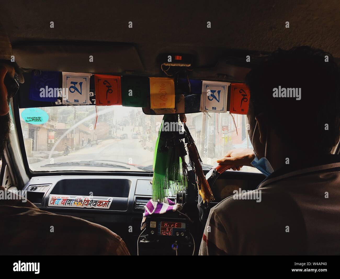 Taxifahrer fahren durch staubige Stadt mit Fahnen in Fenster Stockfoto