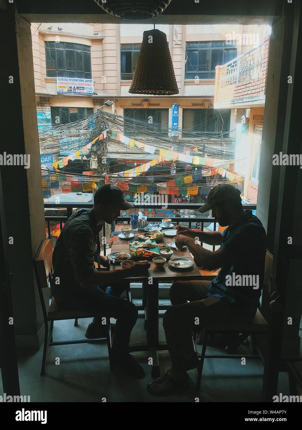 Zwei Männer essen Mittagessen mit Blick auf die Straßen der Stadt in Asien Stockfoto