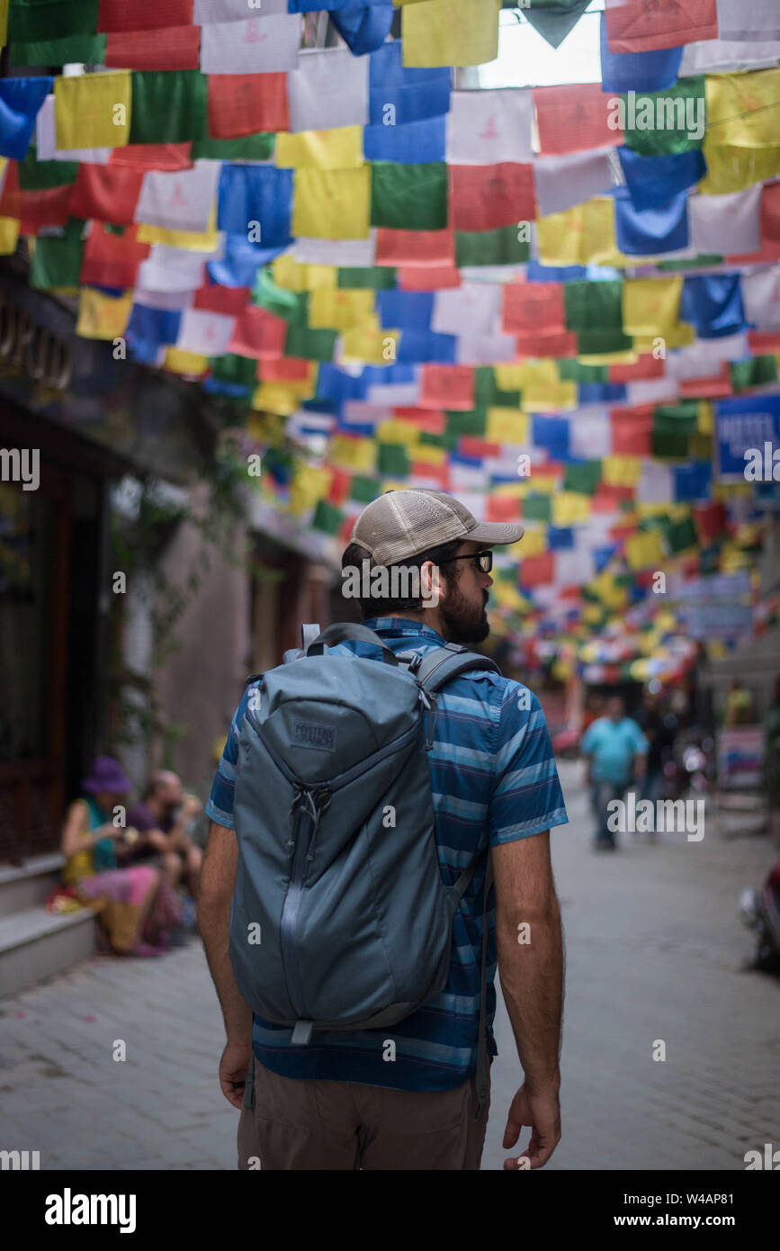 Junger Mann wenige Straßen von Nepal, mit Himalaya Flags Stockfoto