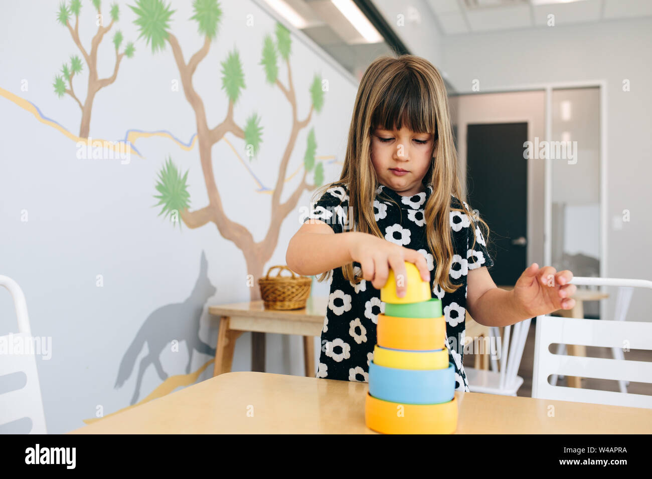 Kleines Mädchen Stapel Zylinder in einer Bildungseinrichtung Stockfoto