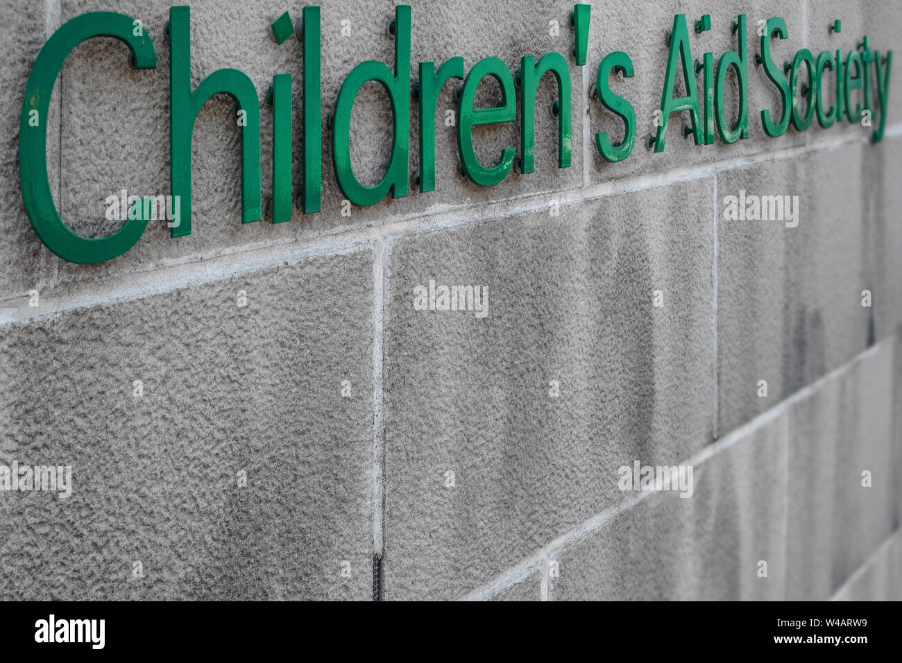 Das Logo des Kinder- Beihilfen, die Gesellschaft auf eine Betonwand. Perspektive betrachten. Stockfoto