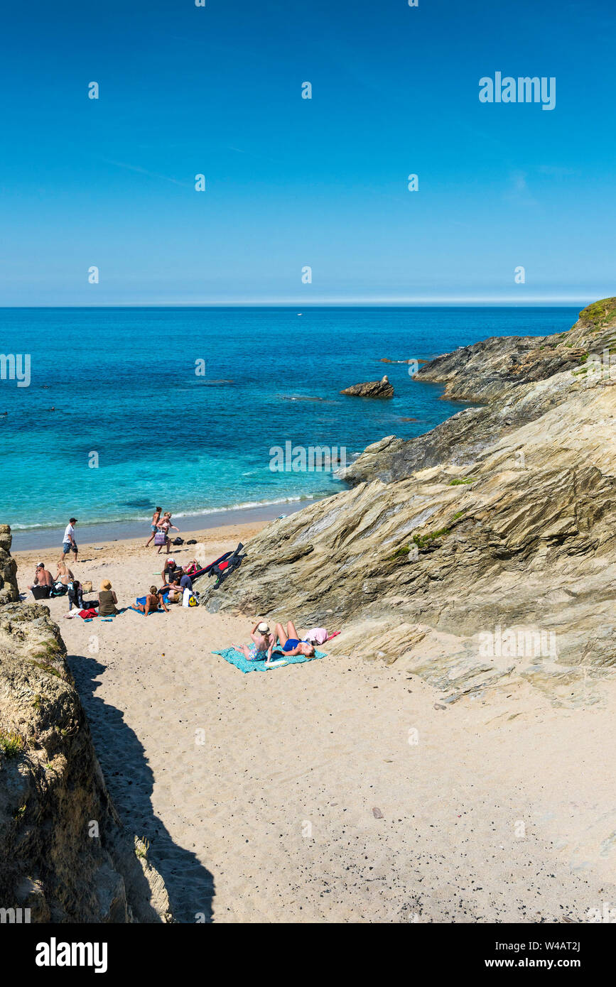 Urlauber entspannen und genießen Sie die Sonne, während Sie am Strand von Little Fistral in Newquay in Cornwall sonnen. Stockfoto