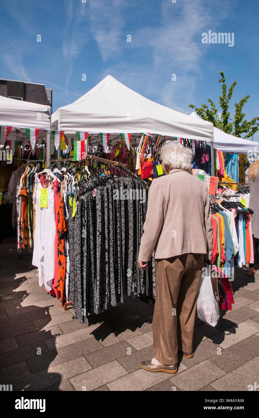Dame suchen in bunten Kleidern auf wöchentlichen Markt im Freien Stall an einem sonnigen Tag in Poulton le Fylde Lancashire England UK-Markt findet jeden mondayVerti Stockfoto