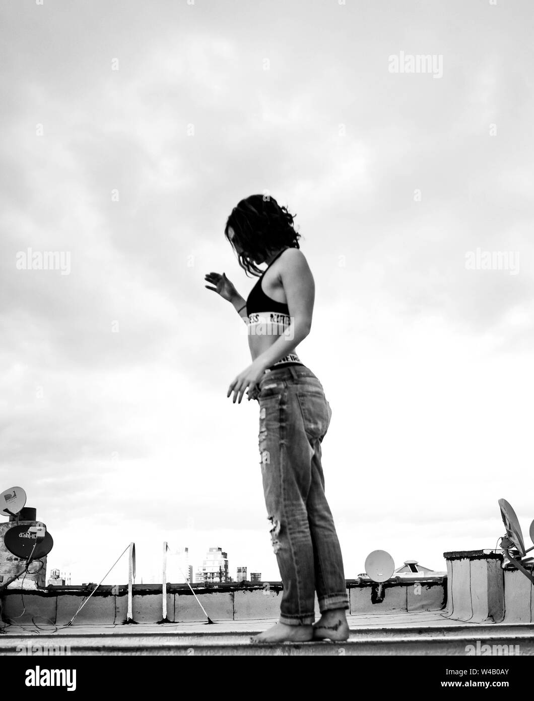 B+W Side Shot der jungen Frau, die auf dem Dach in Brooklyn Stockfoto