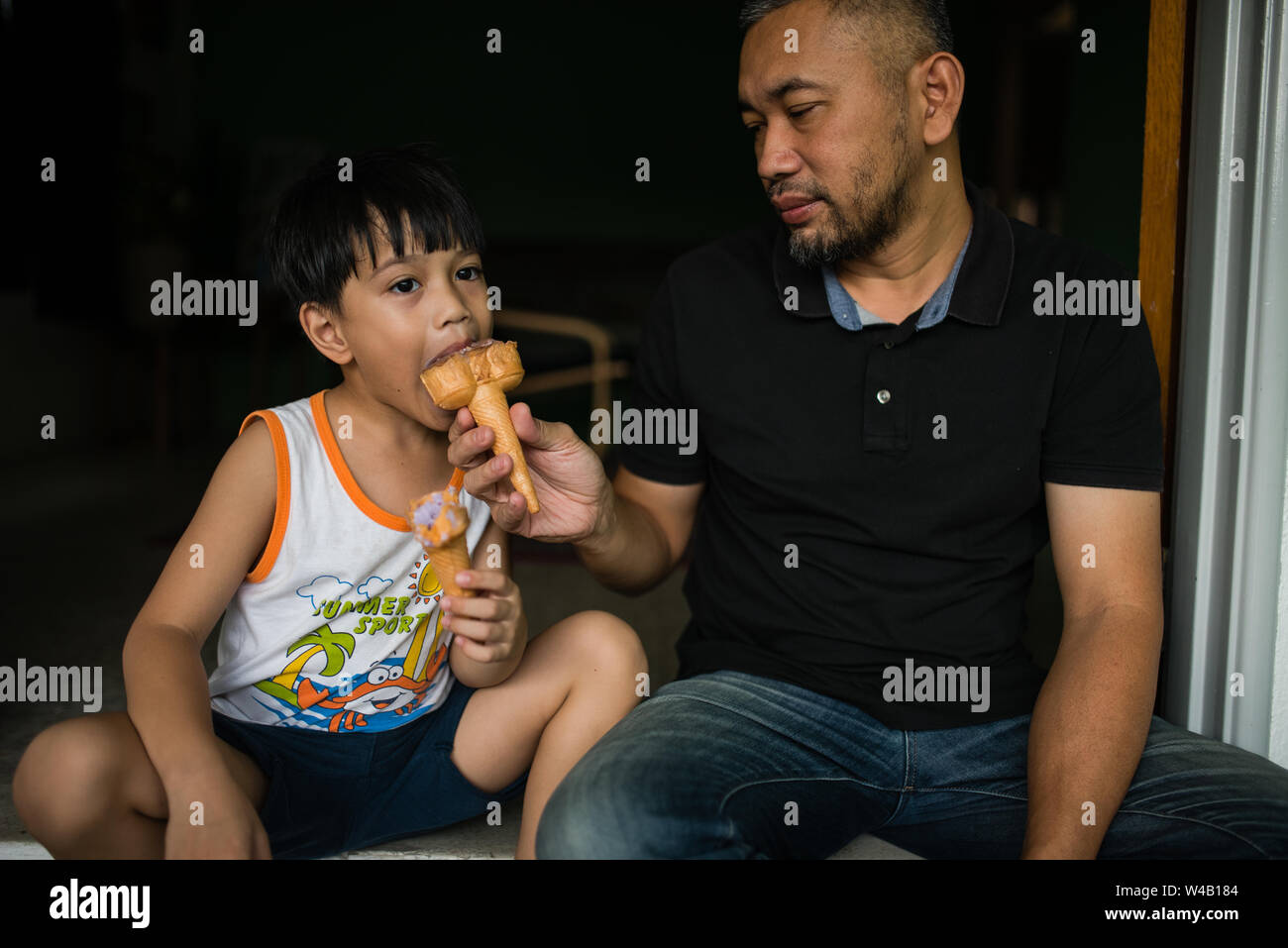 Junge und Vater Eis essen Stockfoto