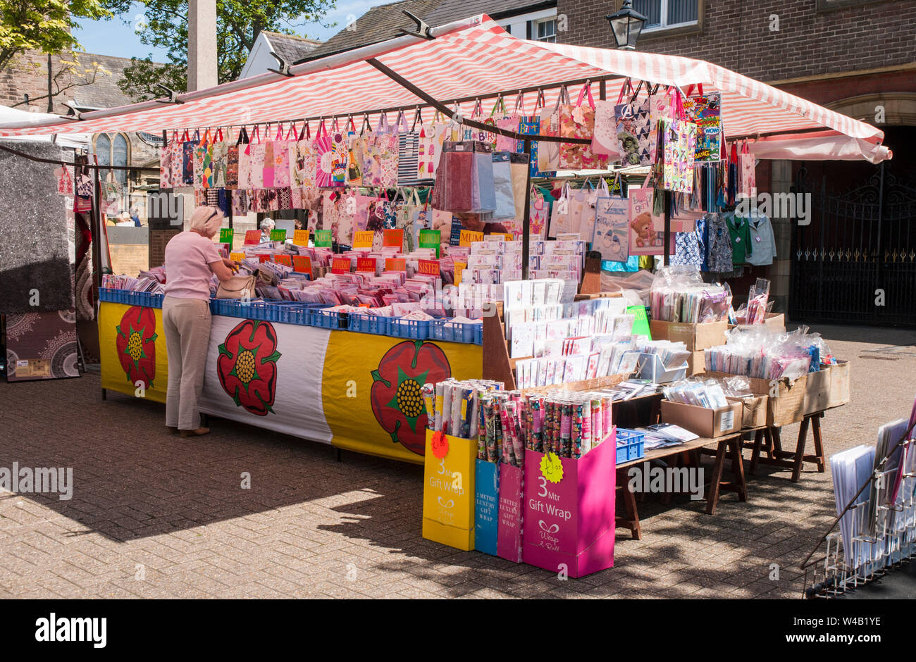 Dame suchen Bei Karten auf Wochenmarkt auf dem Marktplatz an einem sonnigen Tag an Poulton le Fylde Lancashire England UK Abschaltdruck Stockfoto