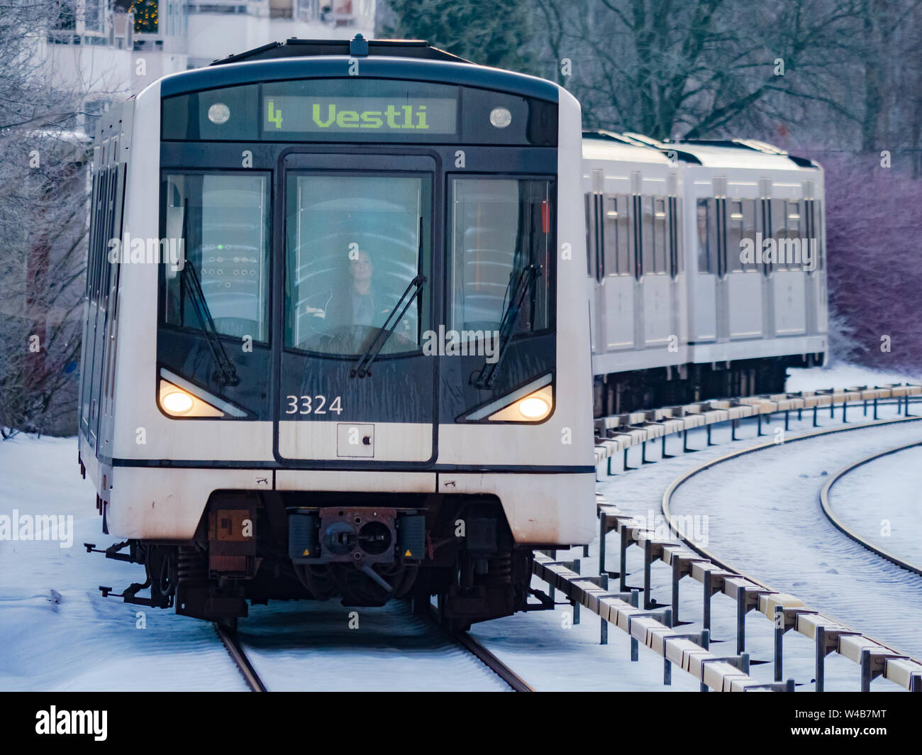 Oslo, Norwegen - 28. Dezember 2018: Die Stadtbahn in Oslo, T-Banen, Lambertseter Bahnhof ankommen Mit einem eingefrorenen Winter Landschaft im Hintergrund Stockfoto