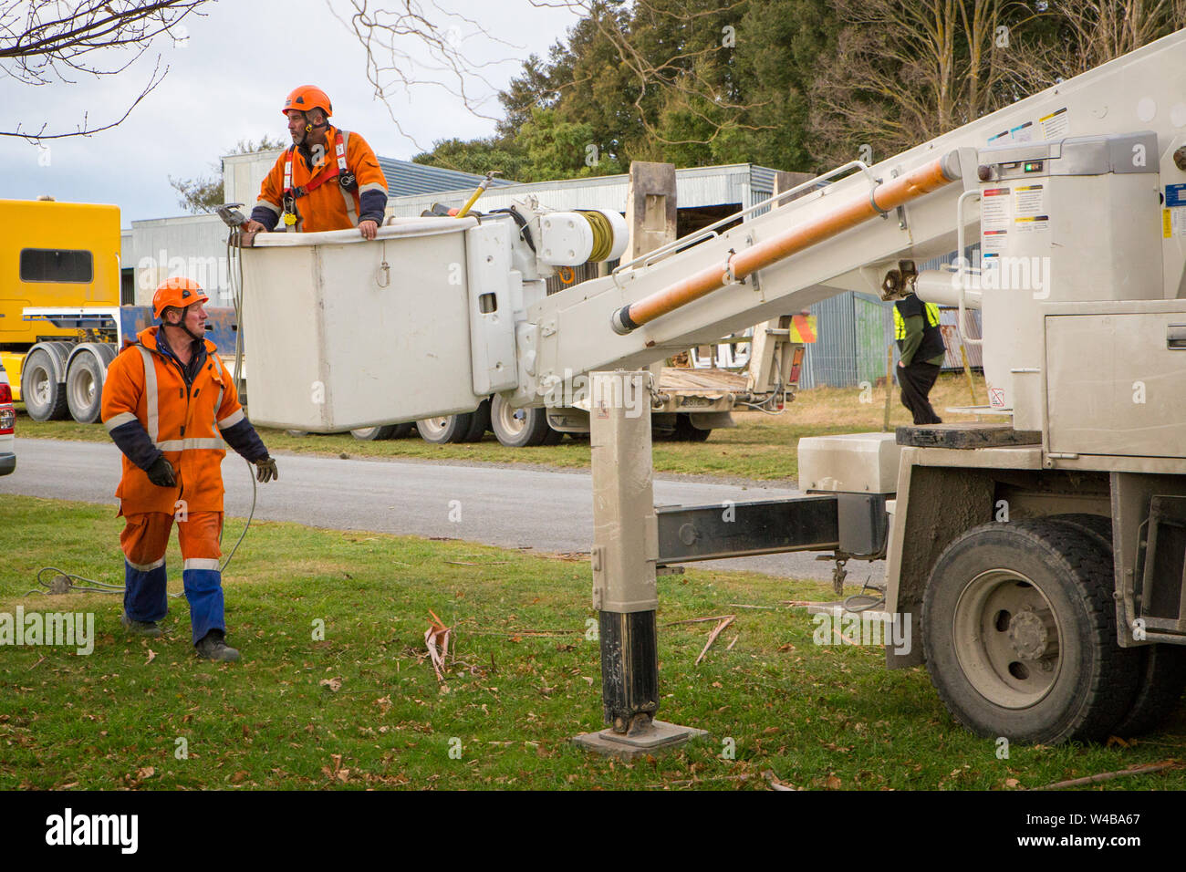 Sheffield, Canterbury, Neuseeland, 10. Juli 2019: Linienrichter aus der Power Company vorbereiten in einem Cherry Picker zu gehen, um auf die oben genannten Stromleitungen zu arbeiten Stockfoto