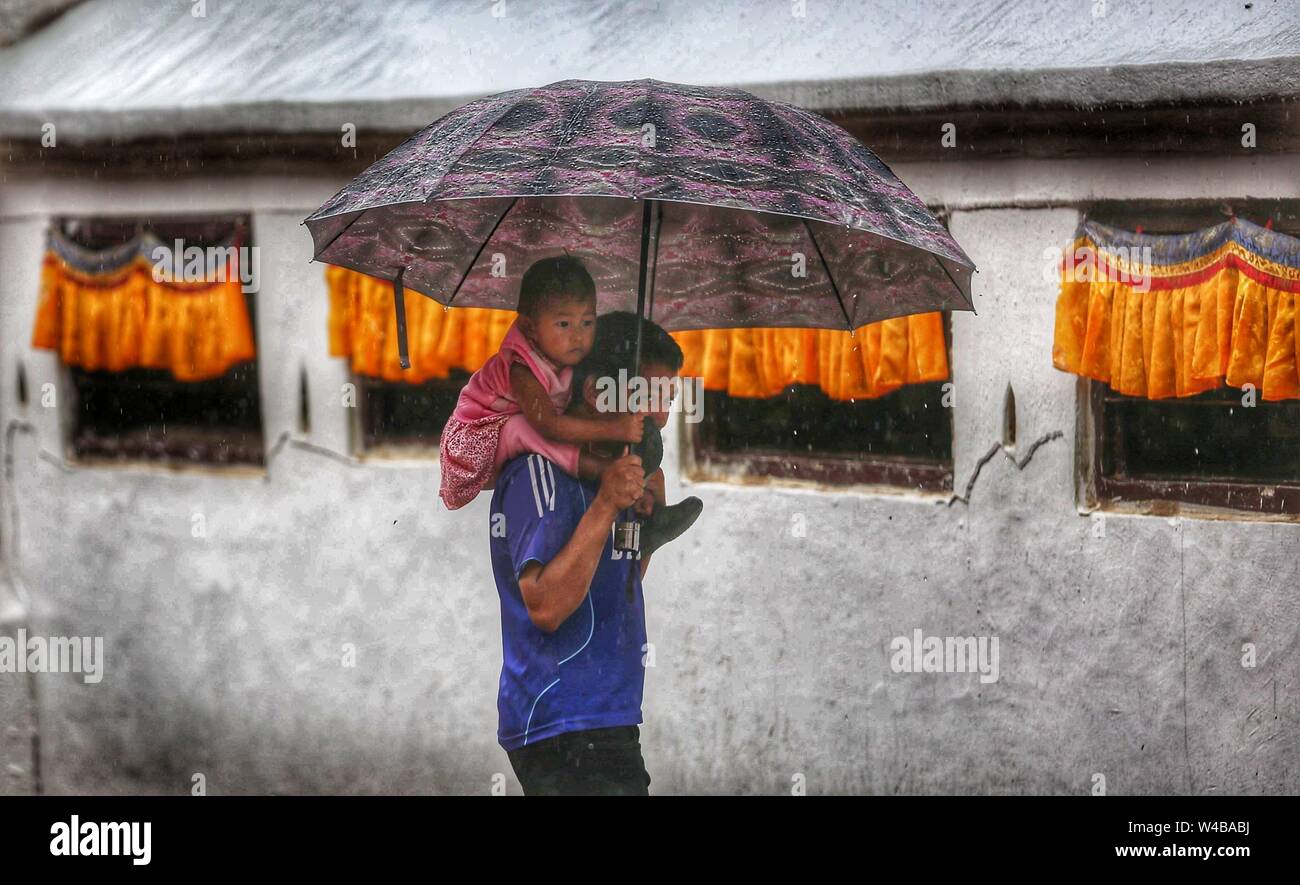 Peking, Nepal. 20. Juli 2019. Ein Mann, der ein Kind geht vor Niederschlag in Boudha in Kathmandu, Nepal, 20. Juli 2019. Credit: Sunil Sharma/Xinhua/Alamy leben Nachrichten Stockfoto