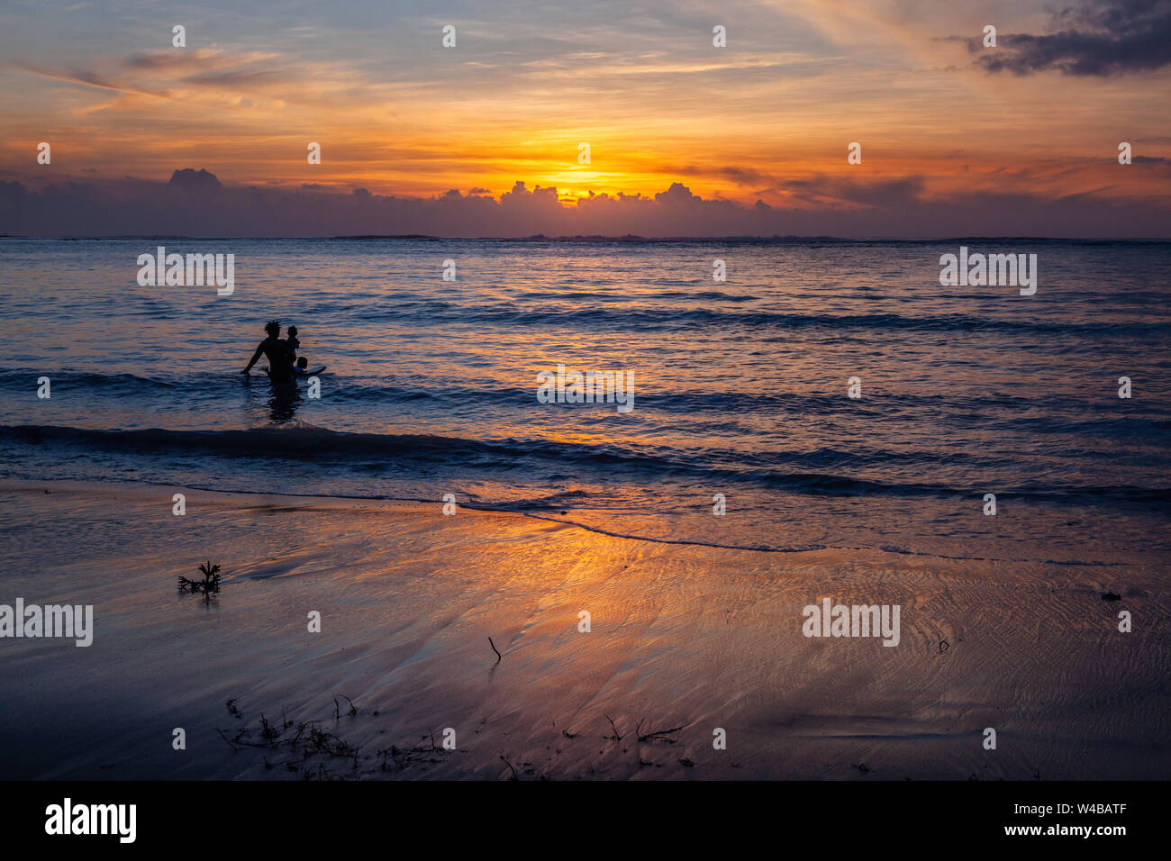 Das Spielen in der Brandung bei Sonnenuntergang, Agana Bay, Guam Stockfoto