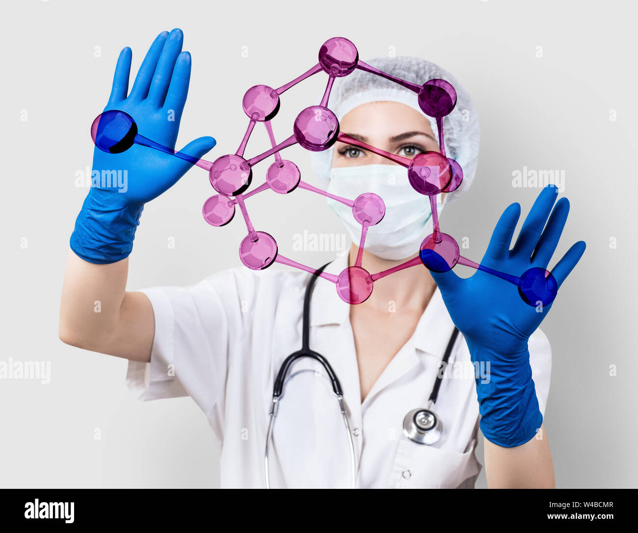 Arzt Frau steuert virtuelle Moleküle in Händen. Stockfoto