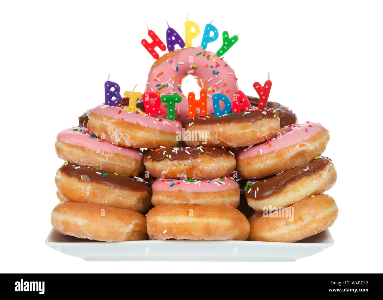 Vielzahl von Glasierten Krapfen mit Happy Birthday Kerzen gestapelt, auf weissem isoliert. Rosa Erdbeere und brauner Schokolade auf einem porzellanteller. Stockfoto