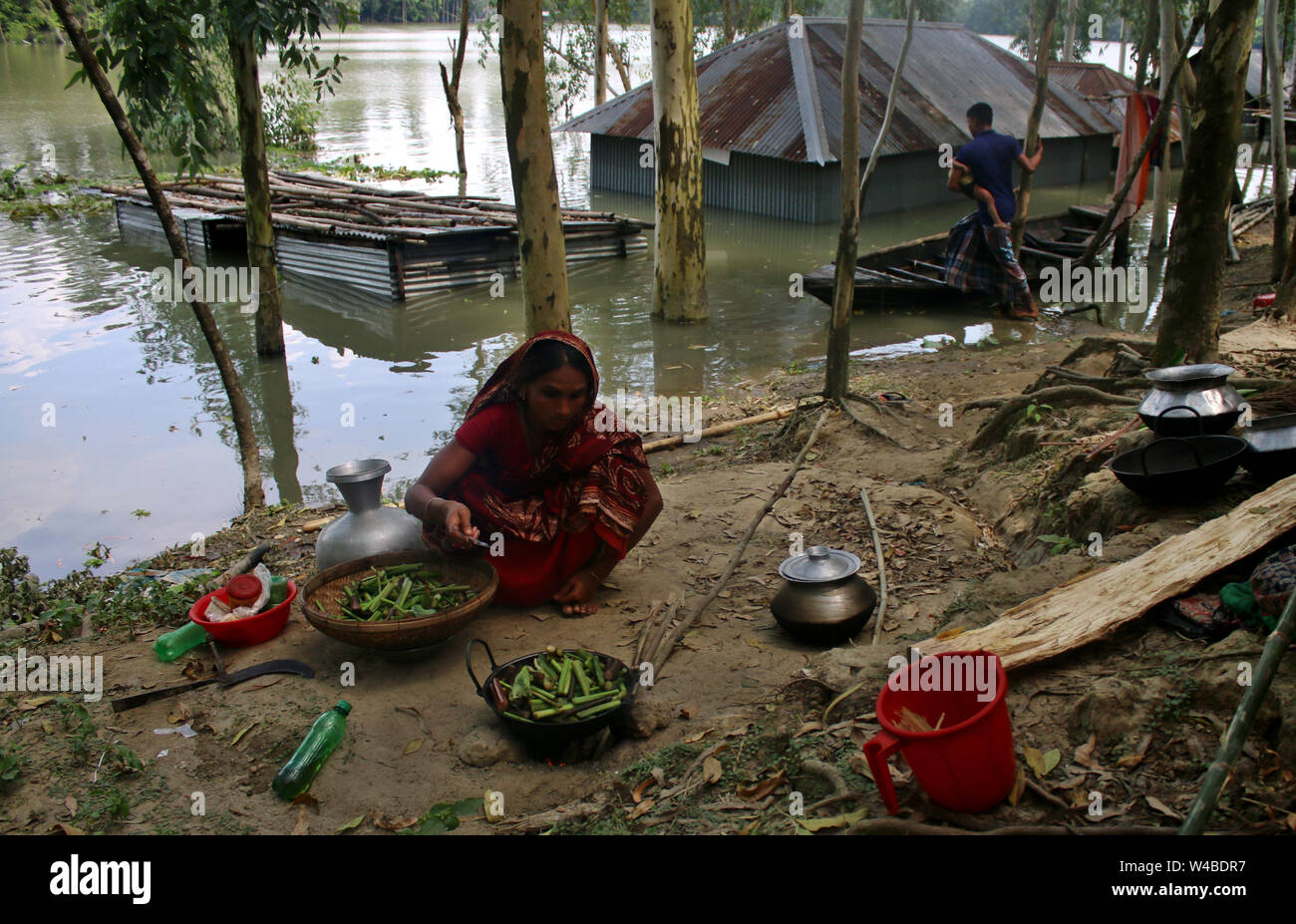 Tangail, Bangladesch. 21. Juli, 2019. Die Menschen nehmen Tierheim neben der Straße nach schweren Monsunregen zu einem Hochwasser betroffene Fläche in Tangail. Über millionen Menschen durch Überschwemmungen durch den Monsun Regen und ausufernden Fluss im Norden, Nordosten und hügeligen Regionen in Bangladesch ausgelöst betroffen. Credit: SOPA Images Limited/Alamy leben Nachrichten Stockfoto