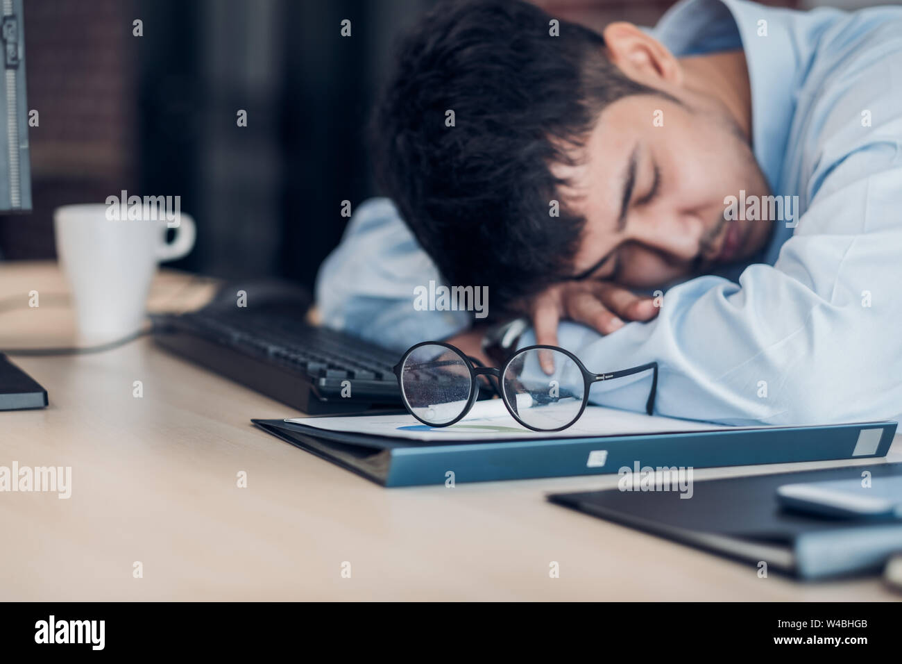 Müde asiatische Geschäftsmann schlafen auf Schreibtisch Tisch im Amt. arbeiten hart und spät. burn out-Syndrom Stockfoto
