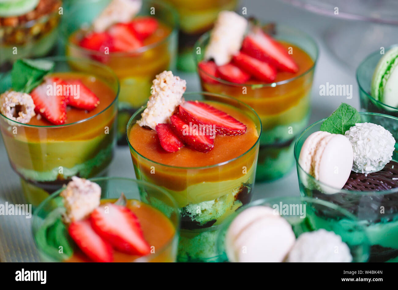 Kleinigkeiten in Kunststoff Gläser mit frischem Obst und Sahne. Stockfoto