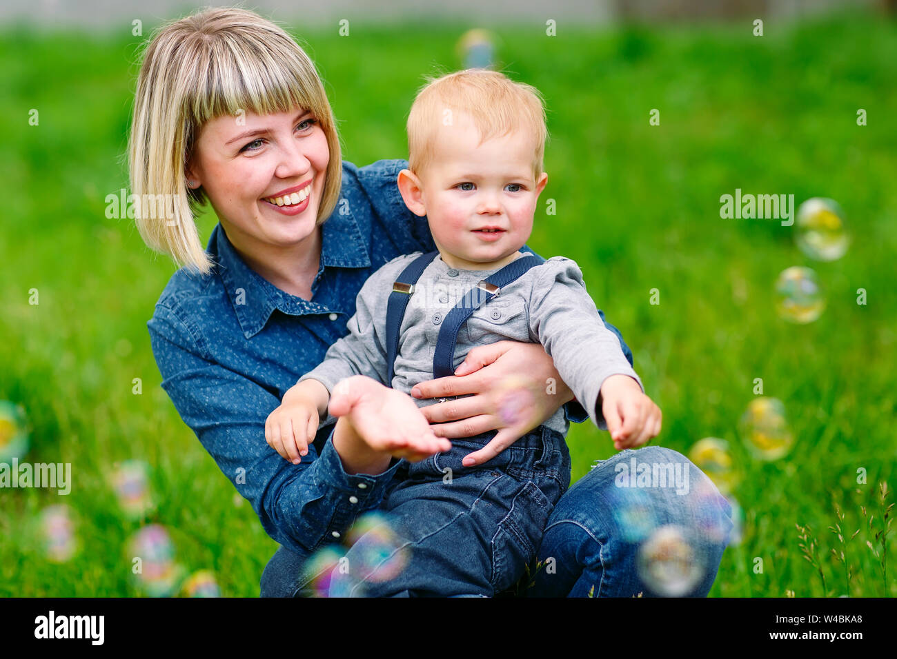 Mutter und Sohn spielen mit Seifenblasen Stockfoto