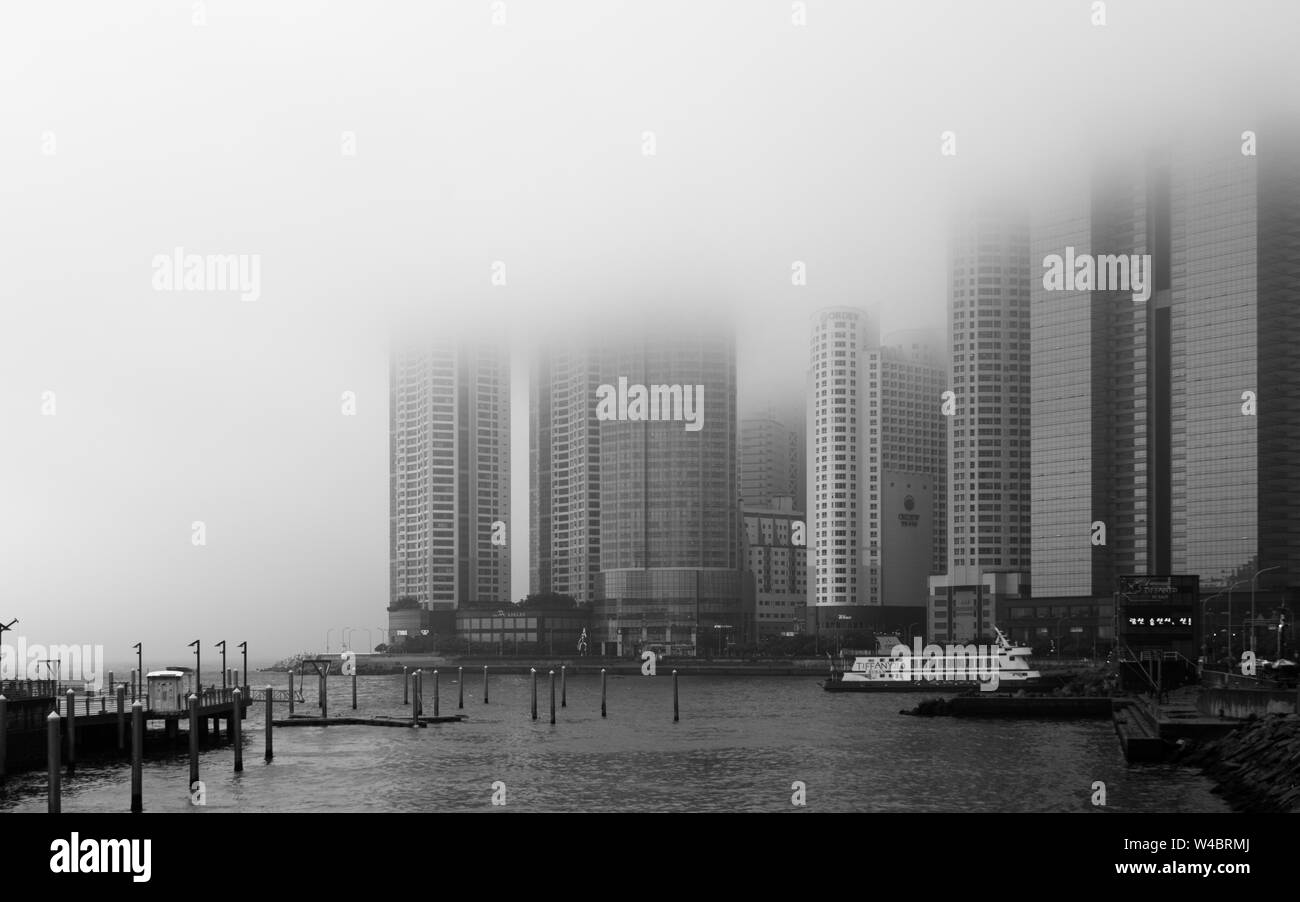 Panoramablick auf die Küste, Hafen mit Promenade und Wolkenkratzer von Hanwha Resort Haeundae an einem nebligen Tag. Haeundae-gu, Busan, Südkorea. Asi Stockfoto