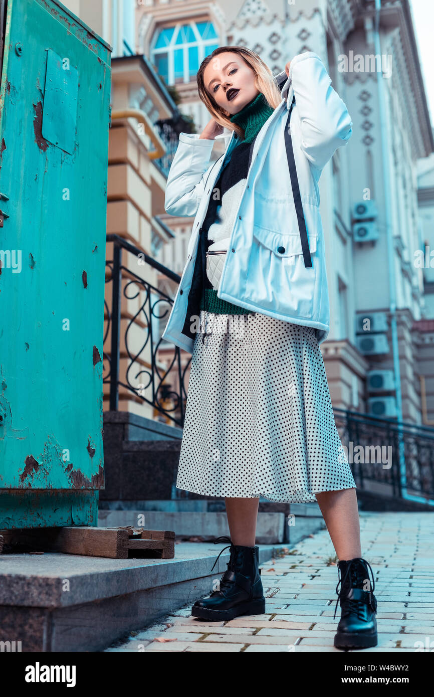 Blonde Modell mit schwarzen Leder Stiefel in der Straße posing Stockfoto