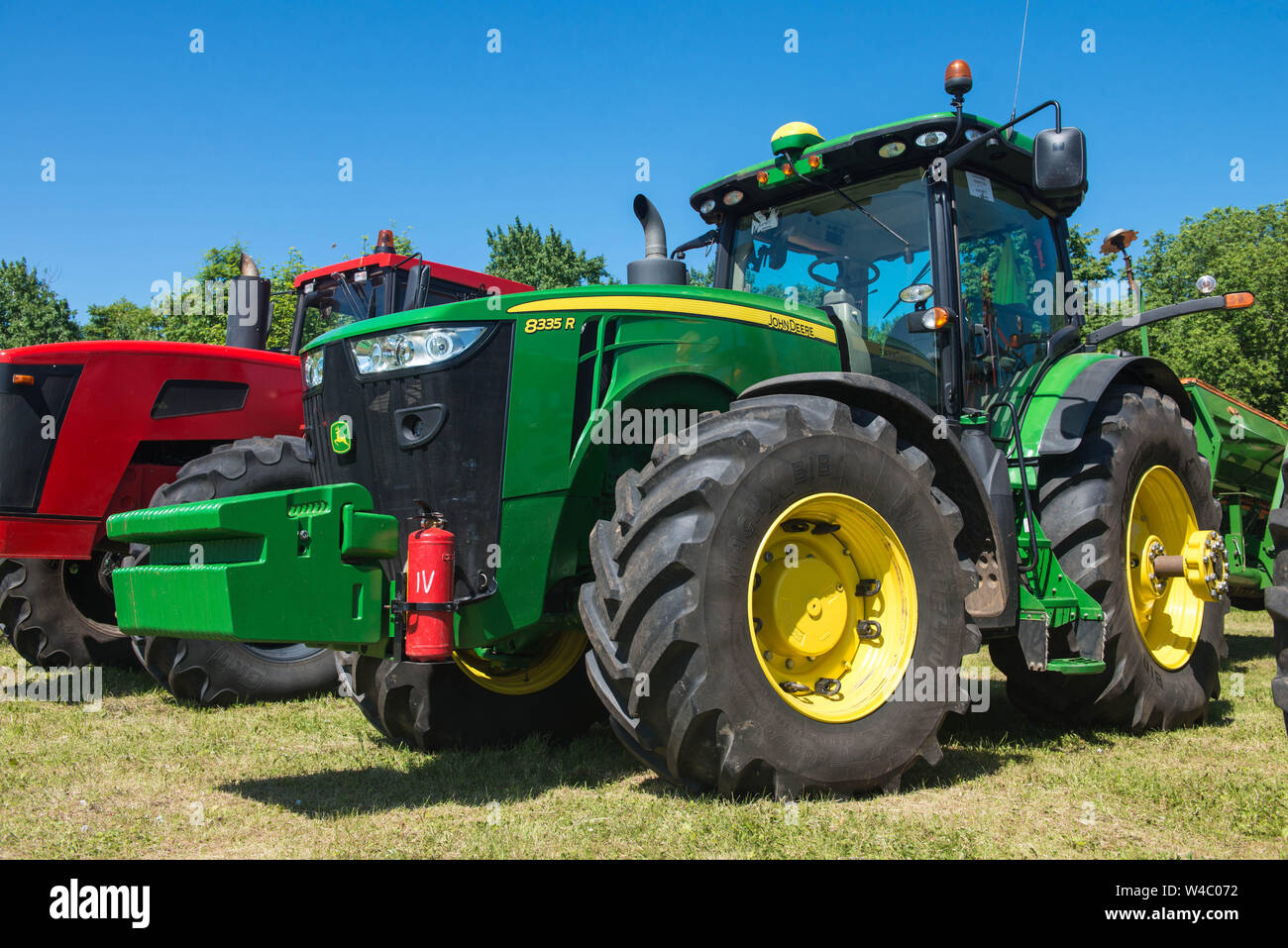 Traktor New Holland, auf das Feld in der russischen Dorf, an einem sonnigen Tag und blauer Himmel. Russland. Tatarstan. Vom 8. Juli 2019. Landwirtschaftliche Maschinen. Stockfoto