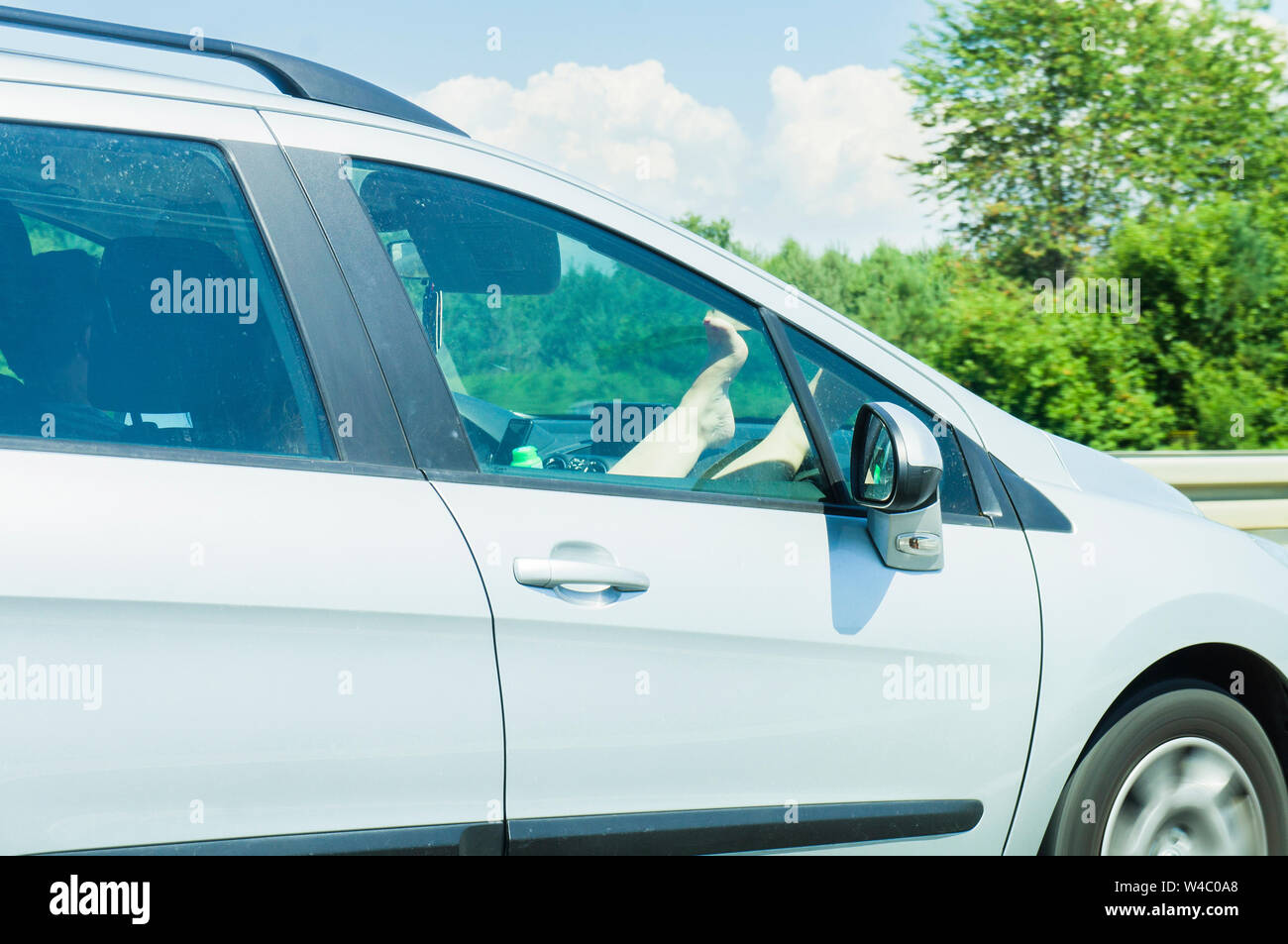 Autobahn A1, weibliche Beine (Bein, Fuß, Fuß) auf dem Armaturenbrett Beifahrerseite (Dash, Instrumententafel), Autobahn, 6. Juli 2019. (CTK Photo/Libor Sojka) Stockfoto