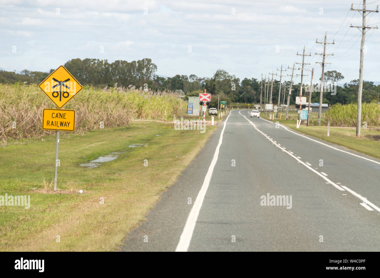 Ein Zucker zug Bahnuebergang Zeichen an einer Hauptstraße in Zuckerrohr Felder in der Umgebung von Mackay, Queensland in Australien. Mackay ist der größte Zucker p Stockfoto