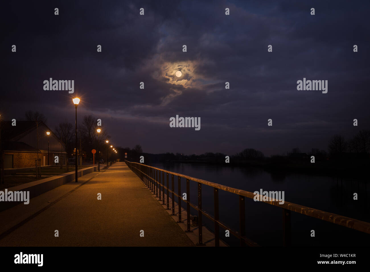 Der Vollmond kommt Quietschen unter den dramatischen Wolken auf der Leie in Wervik, Belgien Stockfoto