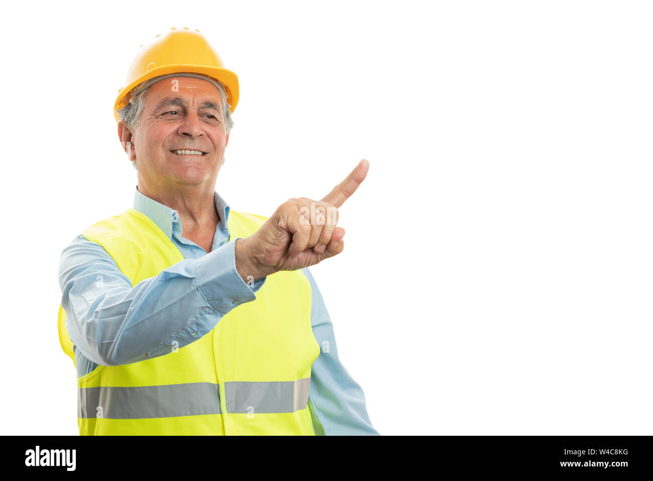 Lächelnde ältere männliche Builder berühren unsichtbare Copyspace auf Anzeige über Index Finger isoliert auf weißem Stockfoto