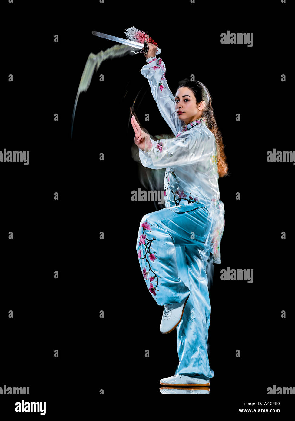 Eine chinesische Frau partacticing Tai Chi Chuan Tadjiquan Körperhaltung studio Schuß auf schwarzen Hintergrund mit Licht malen Effekt isoliert Stockfoto