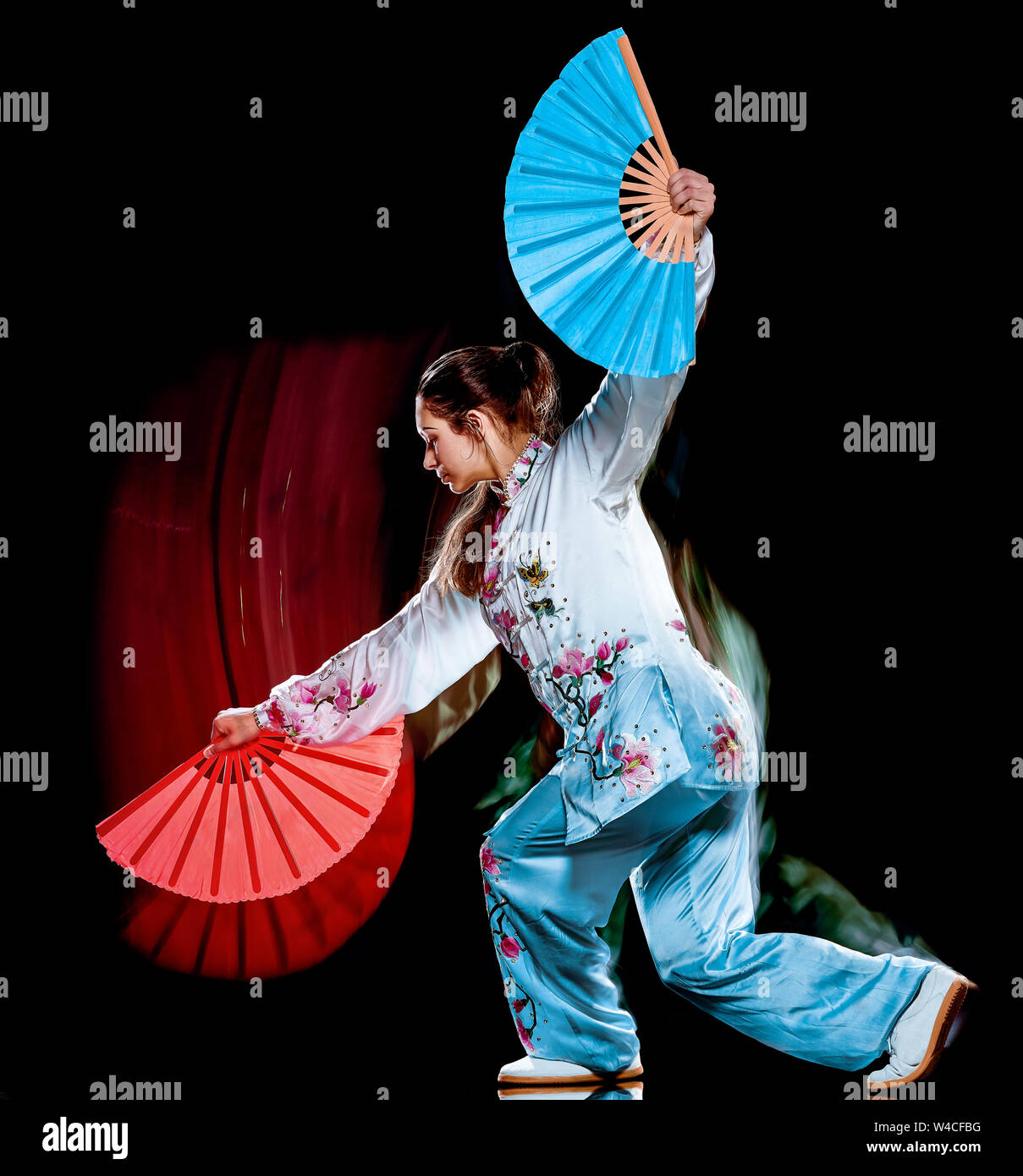 Eine chinesische Frau partacticing Tai Chi Chuan Tadjiquan Körperhaltung studio Schuß auf schwarzen Hintergrund mit Licht malen Effekt isoliert Stockfoto