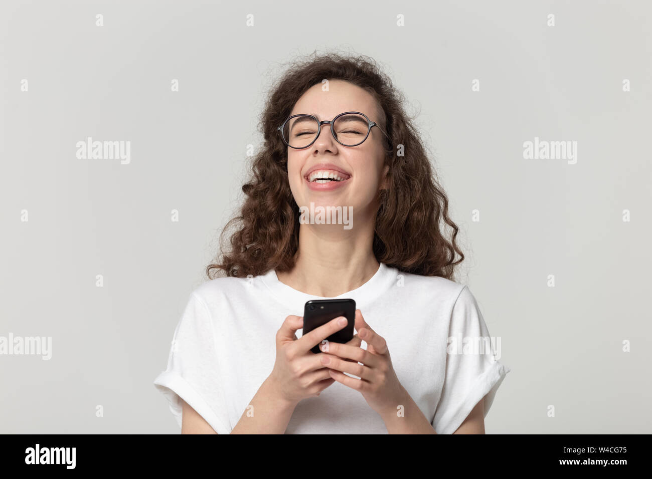 Fröhliche Frau lachend mit Smartphone Apps studio Shot Stockfoto