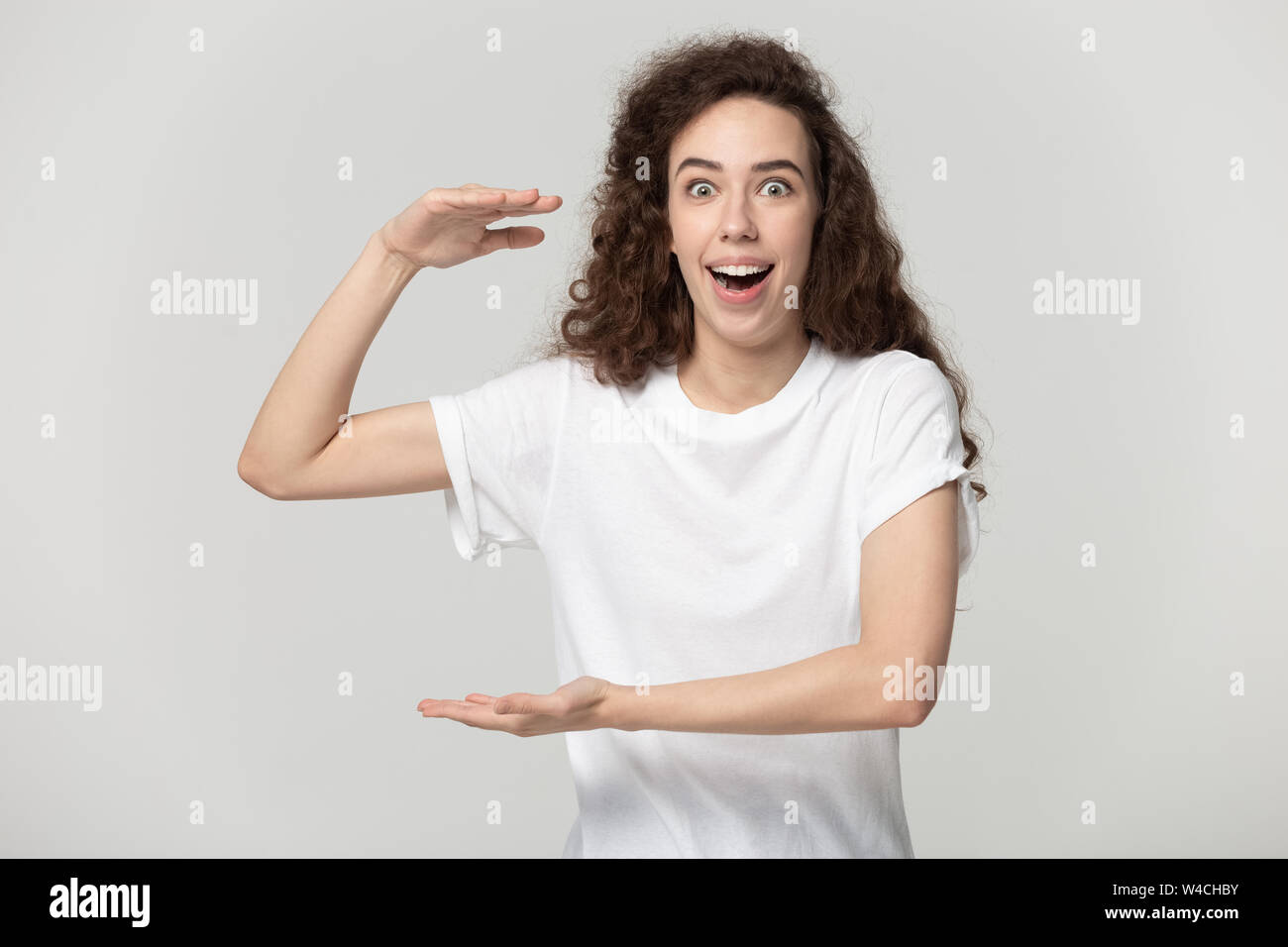 Erstaunt Frau an Kameras mit Händen groß suchen Stockfoto