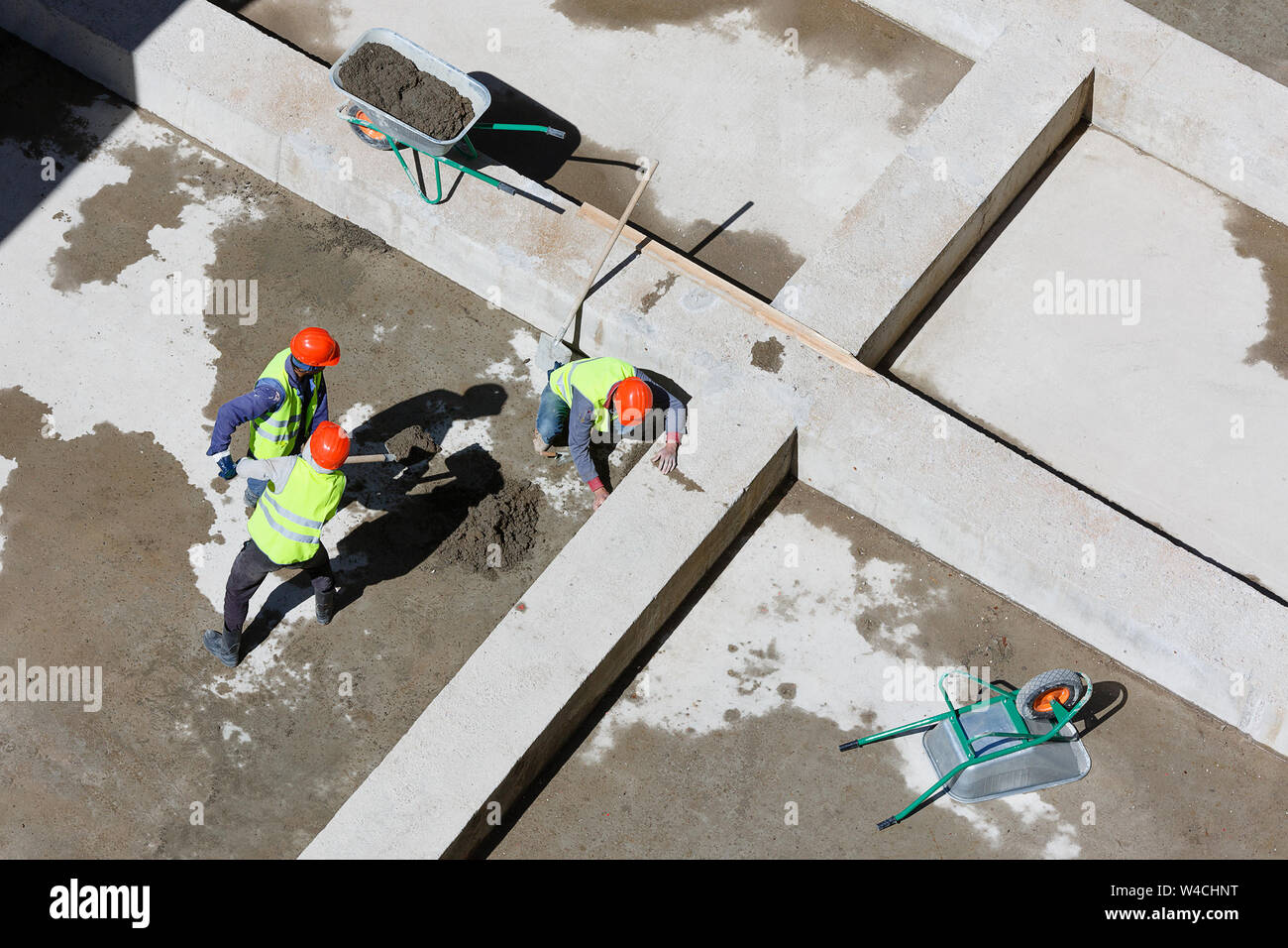 Uniformierte Mitarbeiter sauberen Sand auf einer Baustelle, Ansicht von oben. Stockfoto