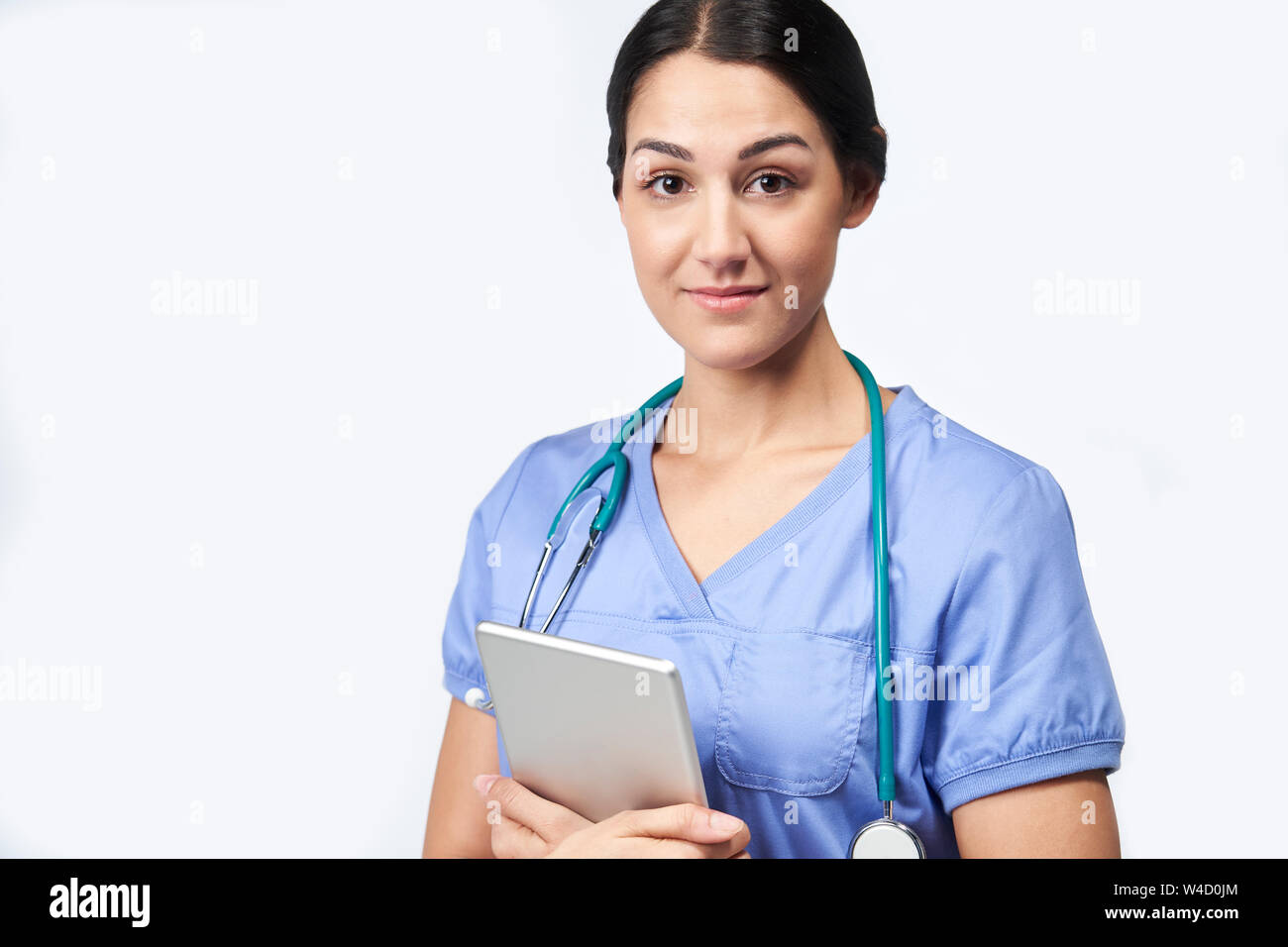 Studio Portrait von weiblichen Krankenschwester Tragen scheuert Holding Digital Tablet Stockfoto