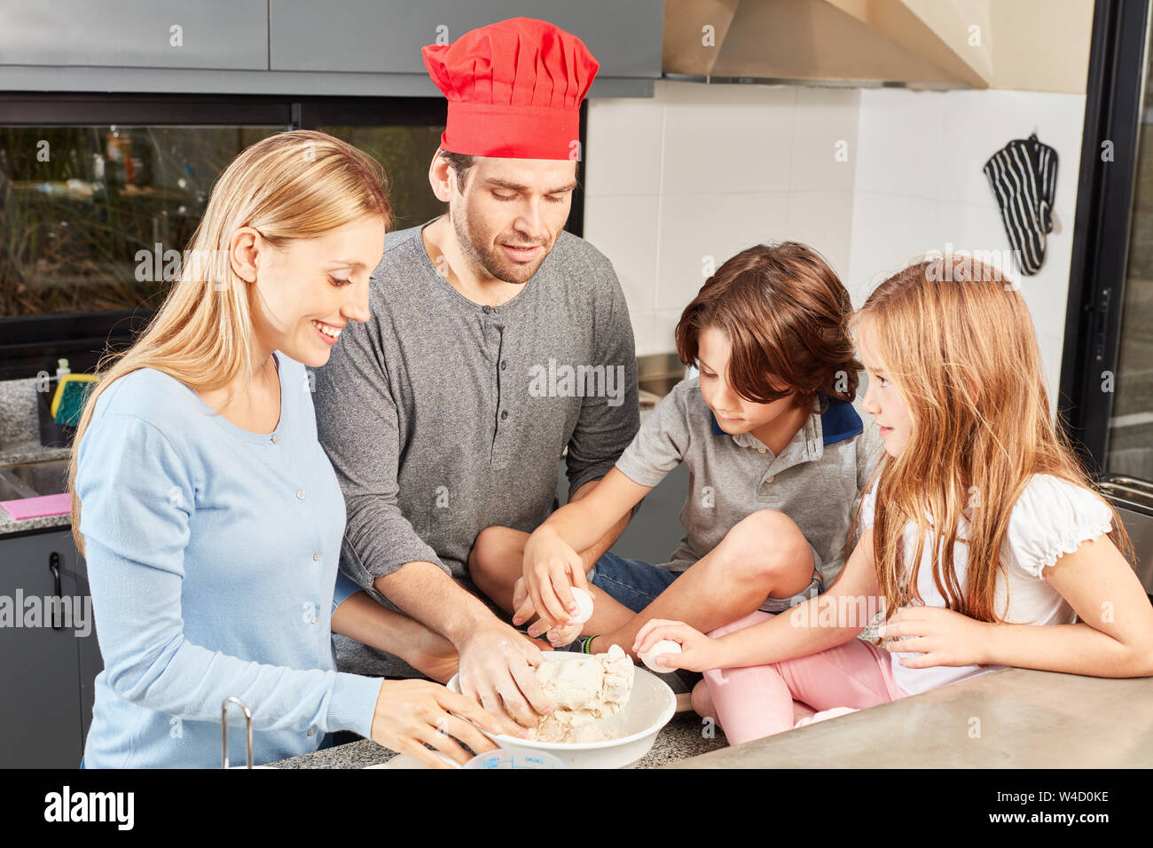 Familie mit zwei Kindern viel Spaß beim Backen von Brot in der Küche Stockfoto