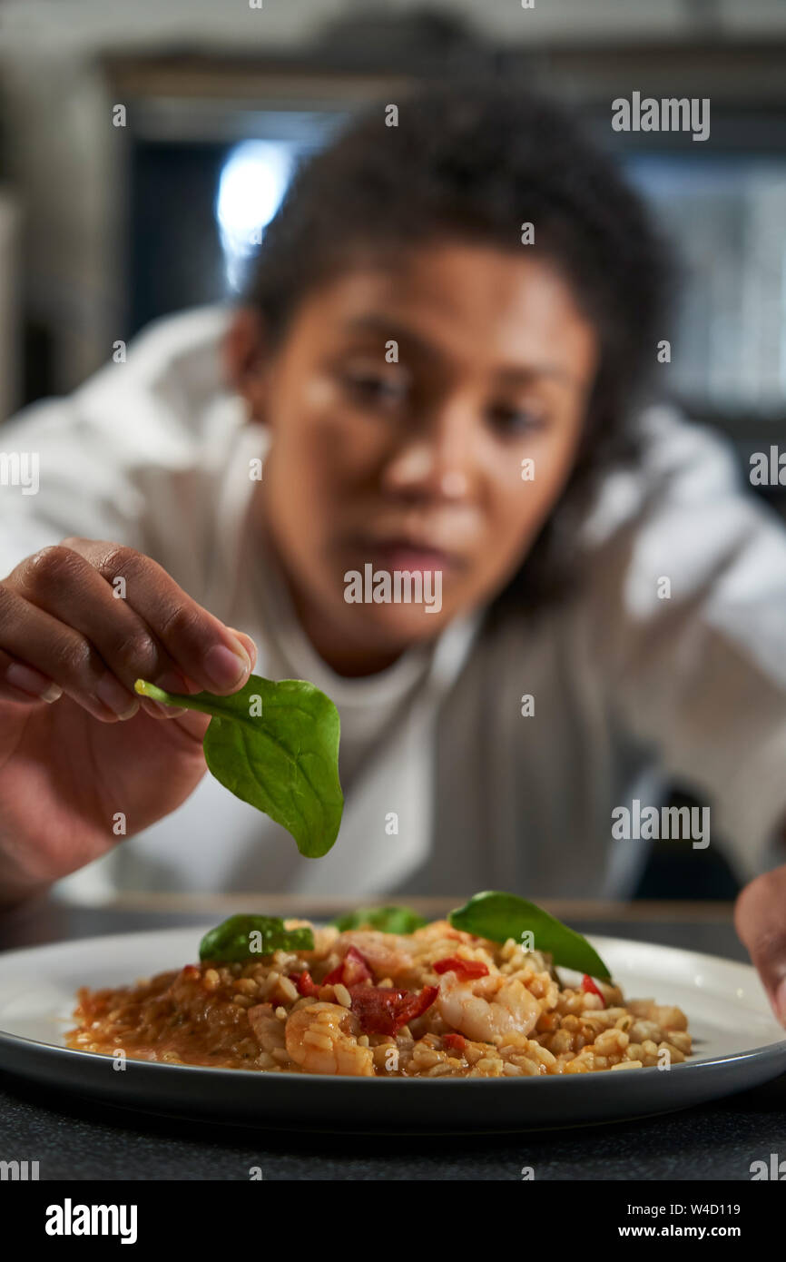 Köchin garnieren Platte von Lebensmitteln in der professionellen Küche Stockfoto