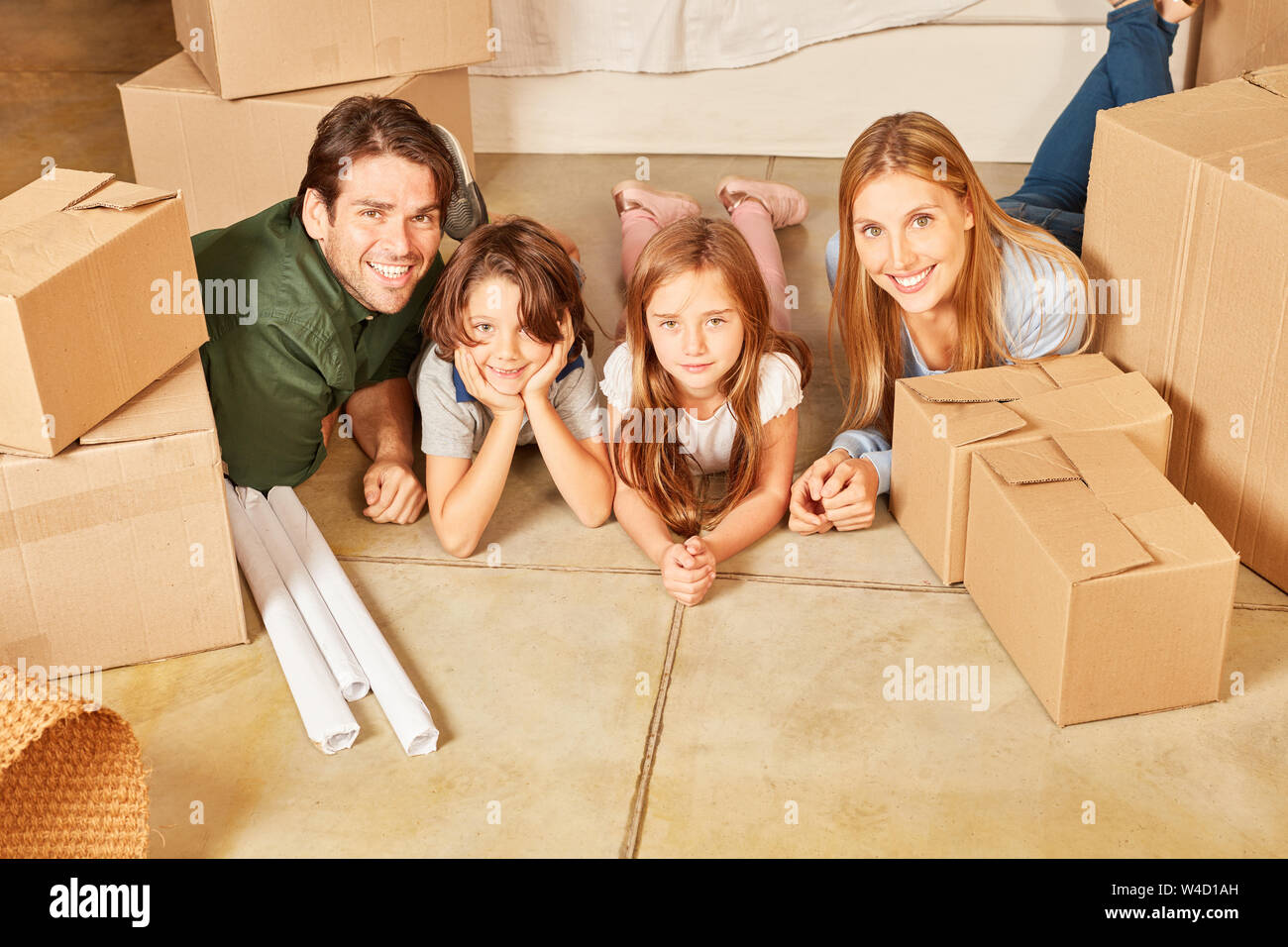 Glückliche Familie mit zwei Kindern in neue Eigentumswohnung zwischen Kartons Stockfoto