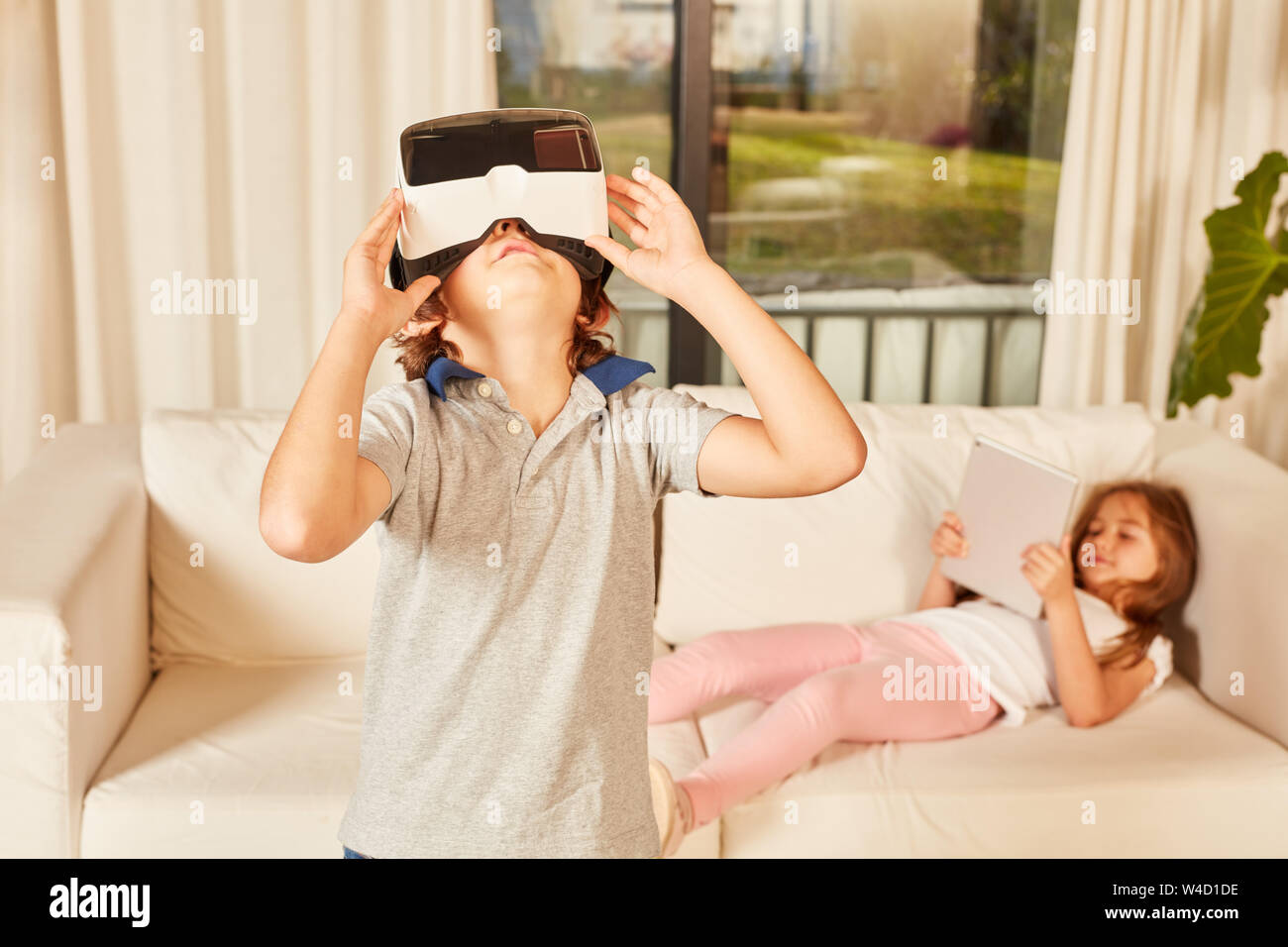 Junge schaut durch 3D-Brille in die neue Wohnung als virtuelle Realität Stockfoto